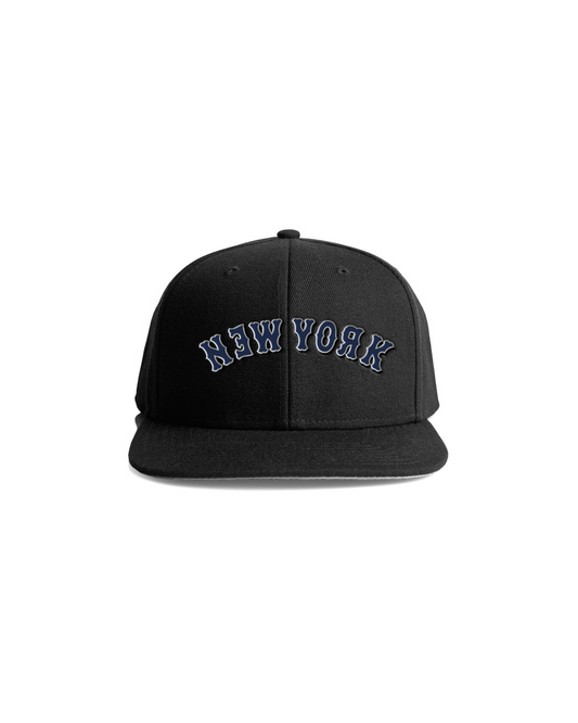 Black snapback cap with "New York" embroidered in blue and white on the front, featuring a flat brim and structured crown.
