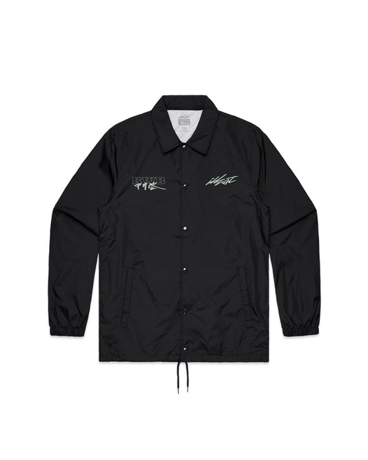 Black coach jacket with embroidered logos on chest, snap buttons, elastic cuffs, and a drawstring hem.