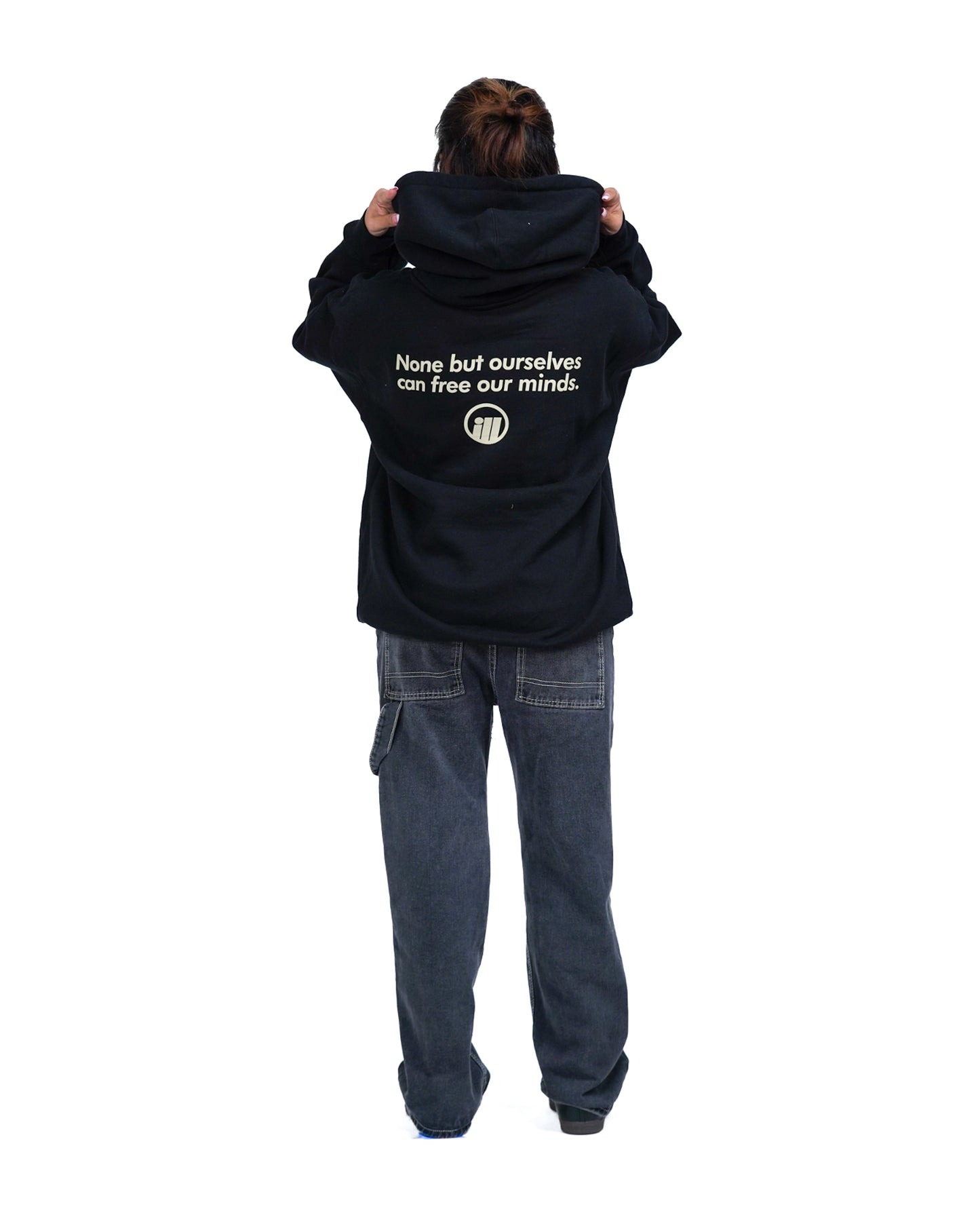 Person wearing a black hoodie with the Illest logo and text on the back, paired with loose dark jeans, standing against a white background.