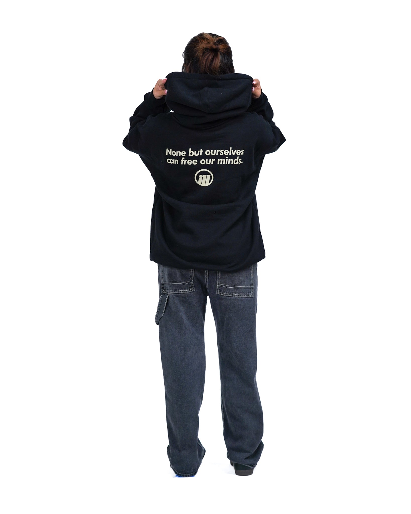 Person wearing a black hoodie with the Illest logo and text on the back, paired with loose dark jeans, standing against a white background.