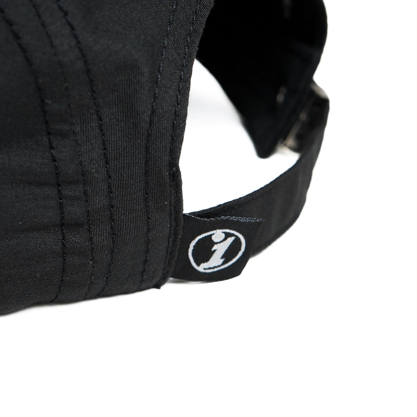 Black Illest Essential five-panel cap with a small logo tag on the strap, featuring a curved brim and adjustable strap.