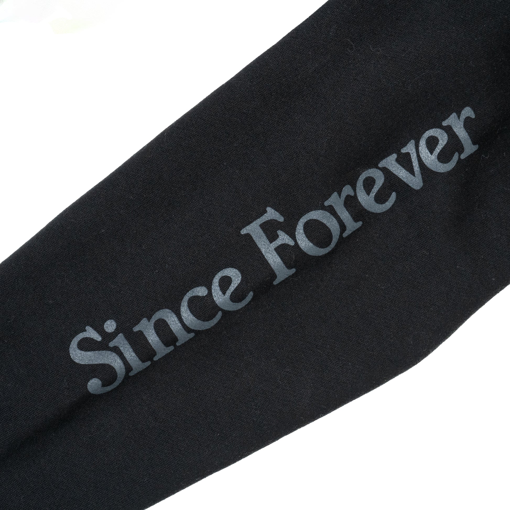 Close-up of a black hoodie with "Since Forever" printed in gray text on the sleeve, showcasing the stylish design.