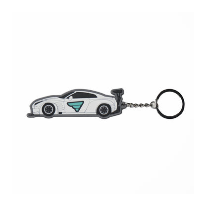 Fatlace GTR car-shaped keychain with a white body, black accents, and a teal logo, attached to a metal chain and ring.