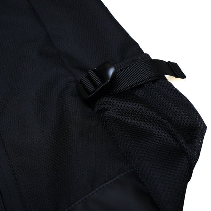 Close-up of a black Illest Travel Tote Bag showing adjustable strap with plastic buckle and mesh pocket detail.