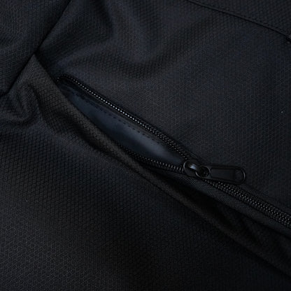 Close-up of a black travel tote bag with a zipper pocket, made of durable textured fabric for versatile travel use.