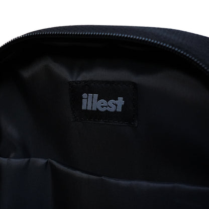 Close-up of the interior of an Illest crossbody bag showing a black fabric label with the Illest logo in gray.