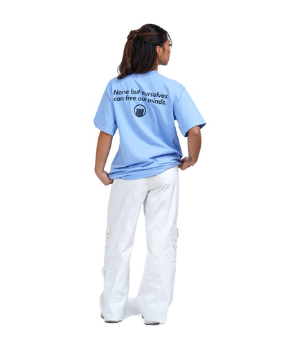 Illest Bold Logo Periwinkle Tee worn by a woman with white cargo pants, featuring a black logo and text on the back.