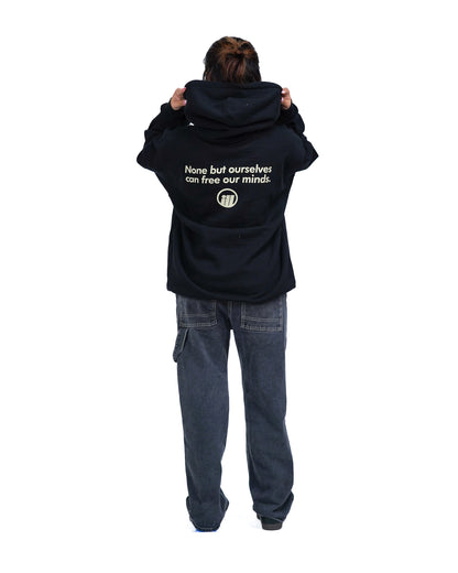 Person wearing a black hoodie with the Illest logo and text on the back, paired with loose dark jeans, standing against a white background.