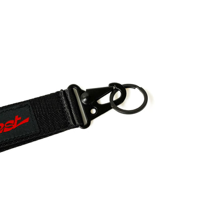 Black fabric keychain with a metal clip and ring, featuring a red and black ILLEST BRAND logo tag.