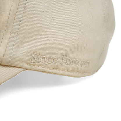 Close-up of a beige dad cap with embroidered "The Illest" logo on the front, showcasing durable fabric and stitching details.