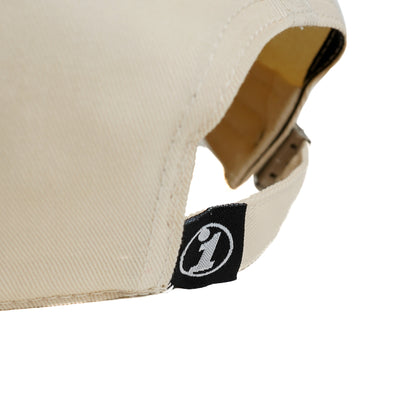 Close-up of a beige Illest Essential Dad Cap showing the adjustable strap and black logo tag on the back.