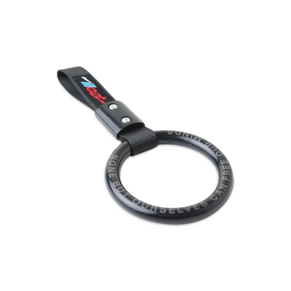 Essential Tsurikawa ring with attached strap, designed for hanging or pulling, featuring a black circular shape with white text.