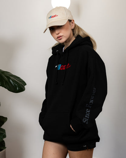 Illest Essential Dad Cap in beige with embroidered logo, worn with a black hoodie and shorts, showcasing casual streetwear style.