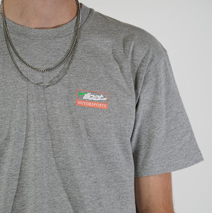 Gray Illest No Limits T-shirt with a small Illest Motorsports logo on the chest, paired with layered silver necklaces.