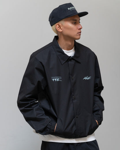 Illest Rough-World Coach Jacket in black with embroidered logos, worn by a model against a plain background.