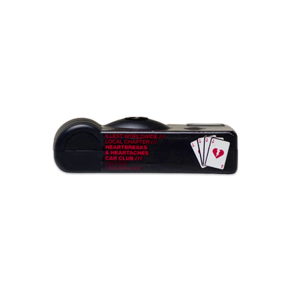 Black disposable camera with red and white text and a playing card graphic, labeled Heartbreak Disposable Camera.